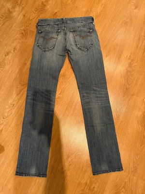 Replay jeans blå straight fit, stl 28 - Snygga blå jeans från Replay med klassisk femficksdesign och coola detaljer på bakfickorna. Jeansen har en rak passform och är tillverkade i slitstarkt denim med lätt tvättad look. Perfekt för dig som gillar en enkel och stilren vibe. Perfekt julklapp!