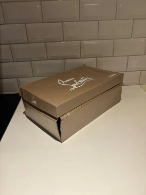 Svarta sneakers från Christian Louboutin - Snygga svarta sneakers från Christian Louboutin med klassisk design och exklusiv känsla. Skorna har snörning och är tillverkade i ett material som ger en lyxig look. Perfekta för dig som vill sticka ut med stilrena detaljer och ikonisk branding.