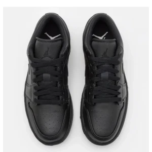 Nike Air Jordan 1 Low Triple Black (splitter nya) - Säljer ett par helsvarta Nike Air Jordan 1 Low med klassisk siluett och snygga detaljer. Skorna har snörning, rund tå och är tillverkade i skinn med en platt sula. Perfekta för dig som gillar stilrena sneakers. Köpta för ca 1400kr säljer för  HELT NYA OCH OANVÄNDA. 700kr