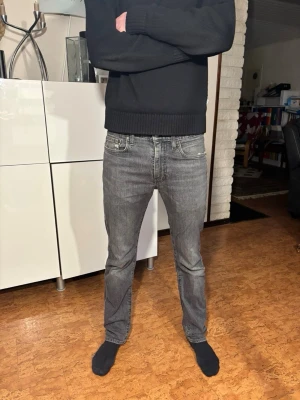Levi’s jeans 502 - Säljer ett par grå jeans från Levis med rak passform och klassisk femficksdesign. Jeansen har normal midja och är tillverkade i mjukt bomullsmaterial. Perfekta för dig som gillar en enkel och tidlös stil. Modell 502
