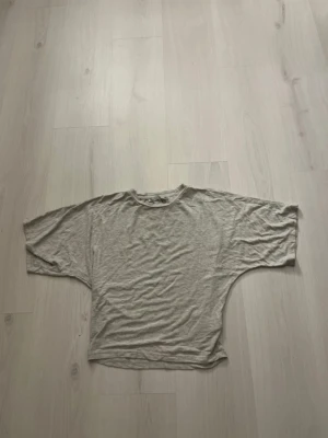 Ljusgrå loose t-shirt från 157 - En ljusgrå t-shirt från 157 med loose passform och breda, korta ärmar. Tillverkad i mjuk bomull och har en enkel rund halsringning. Jättefin💕