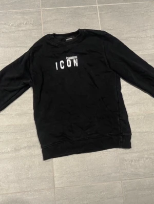 Svart sweatshirt Dsquared2 ICON Size Small - 100% äkta. Knappt använd. Size S. Svart sweatshirt från Dsquared2 med trycket 'ICON' i vitt på bröstet. Klassisk rund halsringning och ribbade muddar vid ärmslut och nederkant. Perfekt för dig som gillar streetwear och vill ha en tröja med attityd. Vid frågor eller funderingar hör av dig 🤙!