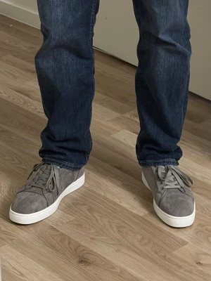 Grå mockasneakers med röd sula - Säljer ett par grå sneakers i mocka från Christian Louboutin med ikonisk röd sula. Skorna har rund tå, snörning och vita kanter runt sulan och jag skickar med dens original påse. Den är perfekta för dig som vill sticka ut, med tanke på att den är grå Christian Louboutin som har vita kant, som ger en clean men ändå unik look. Den är helt ny utan prislapp. Skriv gärna för mer detaljer.