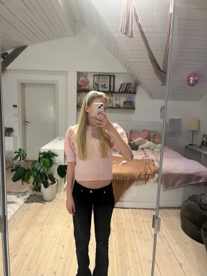 Ljusrosa stickad topp med puffärm - Supersöt ljusrosa stickad topp med korta puffärmar och rund hals. Toppen är croppad och har en mjuk, ribbad kant nedtill. Perfekt för dig som gillar en feminin och trendig stil. Oanvänd med prislapp  från Ginatricot  köpt för 199 kr 