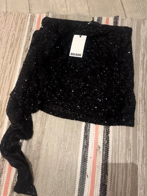Svart paljettkjol från Bik Bok - Snygg svart kjol från Bik Bok täckt med paljetter. Kjolen sitter tight och har lite stretch i sig. Original pris är 600kr men köpt på rea för 400kr. Skulle användas men blev inte så och kommer inte få användning av den, där av säljer jag. 