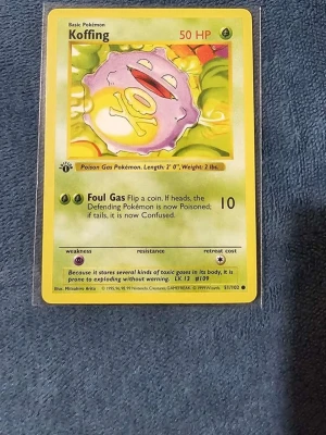 Koffing #51 1st Edition  - Säljer ett sopgrönt och lila Koffing-kort från Pokémon Base Set. Kortet har gula kanter och klassisk design med Koffing-illustration och attacken Foul Gas. Perfekt för samlare eller dig som vill komplettera din samling.