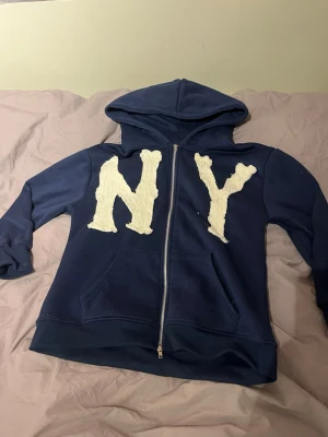 Mörkblå hoodie med NY-tryck - Säljer en mörkblå hoodie med ny tryck på framsidan i storlek s/m