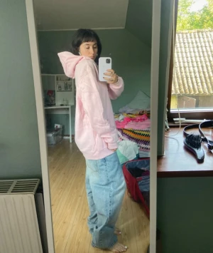 Oversized hoodie - Säljer en ljusrosa hoodie i oversized modell med stor huva och snörning. Tröjan har en klassisk känguruficka framtill och långa ärmar. Mjuk och skön, perfekt för chill dagar. Passar dig som gillar streetwear och relaxed stil.