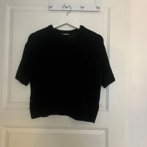 Stickad kortärmad tröja  - Snygg svart stickad tröja från gina. Modellen har korta ärmar och en rundad halsringning, lite croppad. Använd typ 2-3 gånger så den är i väldigt fint skick 🤩 Märkt med ”premium quality” 