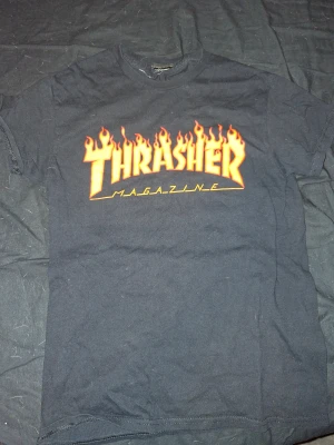 Svart Thrasher t-shirt med flames - Svart t-shirt från Thrasher, lite krackelering på loggan. Storlek S.