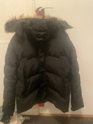 Canada Goose - Säljer nu en svart vinterjacka från Canada Goose med avtagbar päls. Säljer den då den ej kommer till anvönding. Skicket är bra på den. Storleken är L