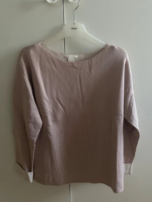 Puderrosa stickad tröja - En stilren puderrosa stickad tröja från H&M med rund hals och långa ärmar. Tröjan har en avslappnad passform och uppvikta muddar vid ärmsluten för en chill vibe. Perfekt för lager-på-lager och passar till jeans eller kjol