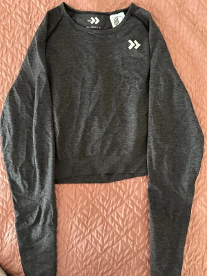 Mörkgrå träningstopp  - Säljer en mörkgrå croppad långärmad träningstopp. Strl M