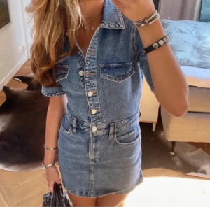Kort jeansklänning med knappar - Snygg kort jeansklänning från Mango i klassisk blå denim. Klänningen har korta ärmar, krage, knappar framtill och fickor både upptill och nertill. Det är den färgen som är på bild 2!!!🩷🩷