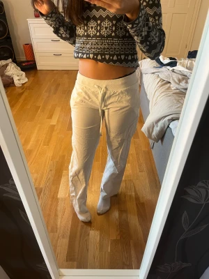 Vita linnebyxor med snörning  - Vita linnebyxor med bred resår i midjan och snörning framtill. Byxorna har raka ben och är tillverkade i ett mjukt material av 95% polyester och 5% spandex. Perfekta för en varm sommardag. Kommer ej ihåg vart jag köpte byxorna men de kostade ca 600kr. De svarta prickarna man ser på sista bilden är ifrån när jag åkte en attraktion på Liseberg har bara prövat tvätta dom så vet ej om prickarna går bort på annat sätt.