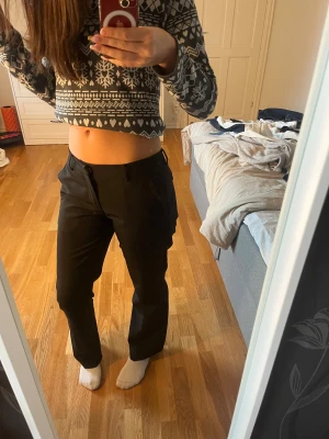 Svarta kostymbyxor från BikBok, stl 38 - Svarta kostymbyxor från BikBok i modellen Vera flare. Byxorna har låg midja, diskreta fickor och stängs med dragkedja och knapp. Snygg passform och stilren look. Byxorna är för korta för mig då jag är 175 lång, passar mig som egentligen har storlek 34 i byxor. På sistabilden kan man se en liten tråd som sticker upp men man tänker inte på den när man har på sig byxorna.