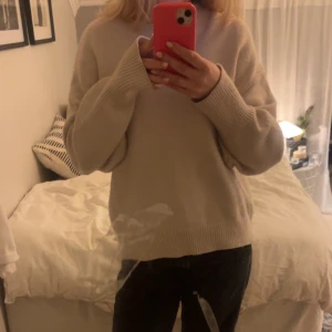 Ljusrosa stickad tröja - Mysig ljusrosa stickad tröja med rund hals och långa ärmar. Tröjan har ribbade muddar vid ärmslut och halsringning, och en loose passform som ger en chill vibe. Perfekt för lager-på-lager under hösten och vintern.