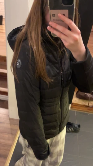 Svart pufferjacka från 8848 Altitude - Snygg svart pufferjacka från 8848 Altitude med huva och coolt logomärke på ärmen. Jackan har dragkedja framtill, två fickor med dragkedja och quiltad design. Perfekt för dig som vill ha en stilren och varm jacka med grym passform. Storlek 160 men passar mig som är xs/s. Originalpriset är 2500