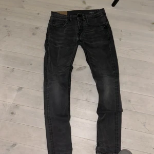Grå/svarta från Dondup - Snygga grå jeans från Dondup i skinny fit-modell. Jeansen har klassisk femficksdesign, svarta detaljer på bakfickorna och en diskret logga. Tillverkade i mjukt bomullstyg med lite stretch för extra komfort. Perfekta för dig som gillar en smal siluett.