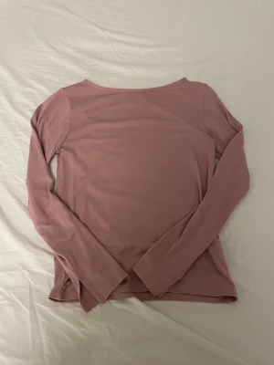 Rosa långärmad tröja  - Säljer en enkel och snygg långärmad tröja i en baby rosa färg. Tröjan har rund hals och är tillverkad i ett skönt bomullsmaterial som passar perfekt till chill dagar. Stilren design utan mönster eller detaljer.