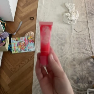 W7 Gloss Away Strawberry Lip Balm - Säljer ett W7 Gloss Away lip balm i smaken Strawberry. Tuben är röd och har en mjuk, glansig formula som ger läpparna en fräsch och söt känsla. Perfekt att ha i väskan för att boosta läpparna med fukt och glans. Innehåller 12,5 ml.