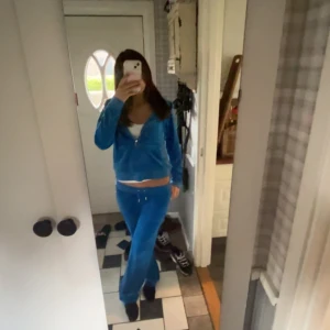 Blå mjukisbyxor Juicy Couture - Säljer mitt blå set från Juicy Couture i storlek XS och M. Byxorna har låg midja, raka ben och snörning i midjan. Materialet är mjukt och skönt, typiskt velour. Man skulle kunna köpa enskild ifall man vill för 350