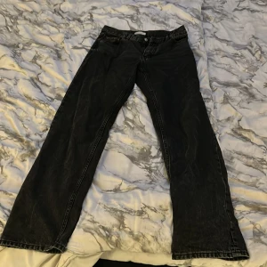 Svarta wide jeans från Gina  - Svarta jeans från Gina/Perfect Jeans i storlek 34. Modellen har raka ben vida längst ned med klassisk femficksdesign och knappgylf. Jeansen är tillverkade i ett robust denimtyg som ger en cool och avslappnad look.