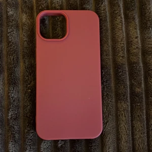 iPhone 13/14 Silikonfodral mörkröd  - Snyggt röd silikonfodral för iPhone 13 eller 14. Fodralet är i mycket gott skick utan synligt slitage eller repor. Ger bra skydd mot stötar och repor, med exakt passform för kamera och portar. Perfekt för dig som vill ge din iPhone ett fräscht och stilrent utseende.