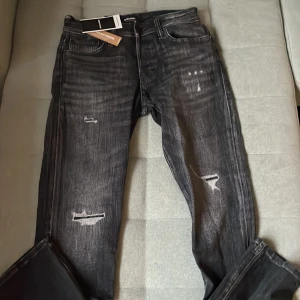 Svarta slitna jeans - Svarta jeans från Jack & Jones med slitna detaljer och snygg tvätt. Finns inte kvar i butik så de är väldigt sällsynta! 