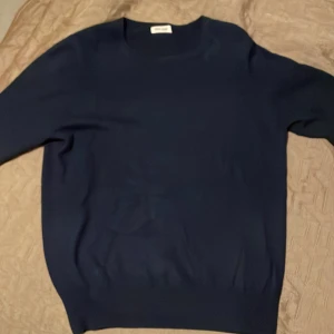Mörkblå kashmirtröja från Soft Goat - Säljer denna stilrena tröja frn Soft Goat. Den är gjord av 100% kashmir för en skön och mysig känsla, perfekt inför de kallare dagarna. Den är i storlek Xl men skulle säga att den passar den som är L då jag anser att den sitter väldigt tight!