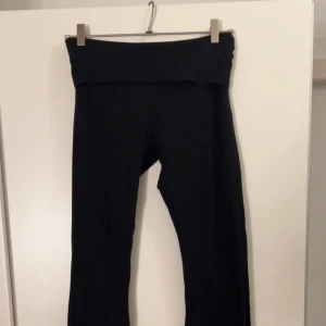 Svarta yogapants  - Svarta leggings från Nelly i mjukt och stretchigt material. Modellen har en bred, vikt linning som ger en bekväm passform och sitter snyggt i midjan. Perfekta för en chill och avslappnad look.