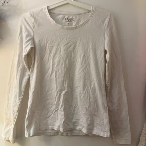 Vit långärmad tröja  - Enkel och stilren vit långärmad tröja från Basic You i ekologisk bomull. Tröjan har rund halsringning och en klassisk passform som funkar till allt. Liten fläck (se bild) finns men inget som syns vid användning. 