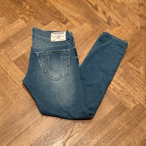 True Religon Jeans  - Ett par riktigt snygga jeans i ett helt utmärkt skick. Passformen är slim fit. Modellen på bilden är 186 cm och väger 83 kg.