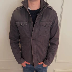 Hilfiger Denim parkajacka - Snygg parkajacka från hilfger,  Jackan har dragkedja och knappar framtill, samt klassisk ståkrage. Perfekt för dig som gillar street och casual stil. Storlek L fits M