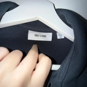 Mörkblå overshirt från Only & Sons - Snygg mörkblå overshirt från Only & Sons med klassisk krage och två stora bröstfickor med knappar. Långärmad modell i mjukt material, perfekt att slänga över en t-shirt. Stängs med knappar framtill och har en clean look utan mönster.