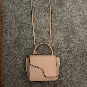 Beige axelväska från ATP Atelier - Snygg beige axelväska från ATP Atelier i stilren design med asymmetrisk lockstängning. Väskan har både handtag och lång axelrem, tillverkad i slätt skinn. Perfekt storlek för det viktigaste och ger en clean look till din outfit. Defekter finns💓 Pris kan diskuteras 💗