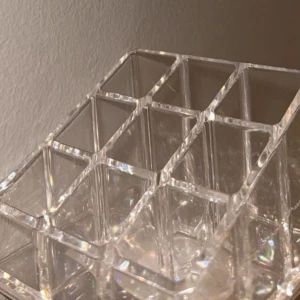 Ny organisering - Bilden visar en transparent förvaringslåda eller organiserare i plast med flera fack. Produkten är ren och i gott skick utan synliga defekter eller slitage. Perfekt för att organisera småsaker, men det är ingen elektronikprodukt. Varan har plasten kvar på. Helt oanvänd