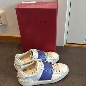 Valentino  Open sneakers blå/vit - Snygga Valentino Garavani Open sneakers i vit med bred blå rem över foten. De hade en skavank i vardera häl i skon, men jag fixa de genom att sätta på en lapp anpassad till skon där. Skriv om nu vill ha fler bilder😇