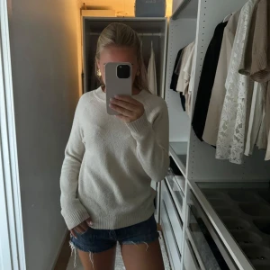 Vit stickad tröja - Säljer en supermysig vit stickad tröja som är perfekt för kyliga dagar. Den har en klassisk rund hals och långa ärmar. Tröjan är i bra skick och passar perfekt till både jeans och kjol. Perfekt för höst och vinter!