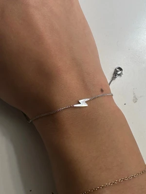 Silverfärgad blixtarmband - Snyggt och stilrent armband i silverfärg med en blixtformad detalj i mitten. Aldrig använt! (Föredrar guld) 