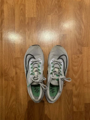 Nike ZoomX sneakers  - Nike ZoomX sneakers med grå mesh-överdel, svarta detaljer och gröna accenter. Använda max 10 löprundor.