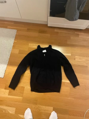 Svart half zip tröja Bruun & Stengade - Svart långärmad tröja från Bruun & Stengade i storlek XL. Blivit mycket mindre efter alla tvättar. Sitter som en medium eller nästan small numera. Fortsatt bra skick dock. Tröjan har en stilren ståkrage med half zip-dragkedja framtill. Materialet är mjukt och känns som ull, perfekt för kyliga dagar.