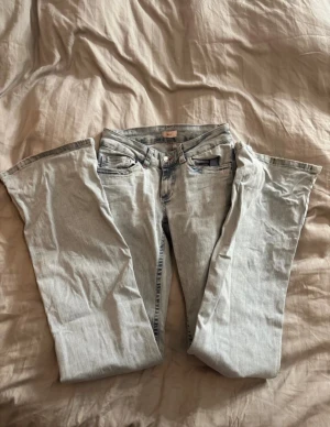 Lågmidjade bootcut jeans från nelly - Hålet på ena knät eller lite mer utdraget och det finns en jätte liten slitning längst ner på jeansen
