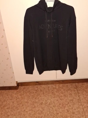 Långärmad tröja - Detta är en snygg och stilren svart tröja för kvinna i storlek L. Tröjan har en tidlös design som gör den enkel att bära vid många olika tillfällen, både till vardags och vid mer uppklädda sammanhang. Den svarta färgen ger ett elegant och klassiskt intryck samtidigt som den är lätt att matcha med andra plagg, såsom jeans, kjol eller kostymbyxor. Passformen är bekväm och ger en fin silhuett utan att kännas för tajt, vilket gör tröjan både praktisk och stilfull. Materialet upplevs som mjukt och be