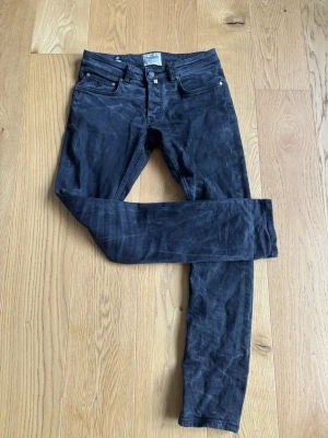 Morris svarta jeans 30/32 - Säljer ett par svarta jeans från Morris i storlek 30/32. De har klassisk femficksdesign, snygga detaljer med logga på myntfickan och bakfickorna samt silverfärgade nitar och knapp. Jeansen har en rak passform och är tillverkade i mjukt bomullsmaterial.