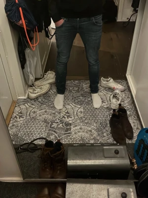 Blå skinny jeans från Jack & Jones - Säljer ett par blå skinny jeans från Jack & Jones med snygg tvätt och klassiska fem fickor. Jeansen har låg midja och smal passform som sitter tajt längs benen. Materialet är jeans med tydliga slitningar och kontrastsömmar. Perfekt för dig som gillar en modern och slim look.