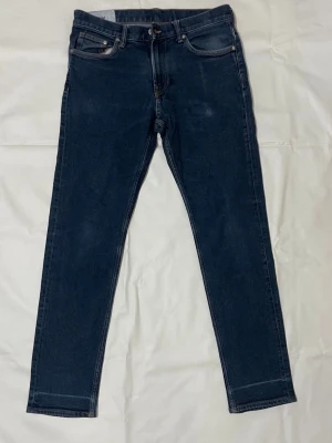 Slim fit blå jeans 32/32 - Slim fit jeans i mörkblå denim med klassisk femficksdesign och smal passform. Byxorna har normal midja och är tillverkade i bomullsmaterial. Perfekta för dig som gillar en stilren och enkel look.