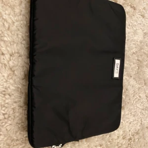 Svart datorväska från DAY ET - Stilren svart datorväska från DAY ET i mjukt, vadderat nylonmaterial. Tag kvar men ej prislapp, är ej använd. 42x31