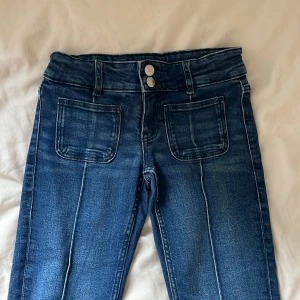 Blå bootcut jeans  - Mörkblåa low waist jeans från Gina tricot young , jag har sprettat upp Jensen på ena benet då jag ville ha de längre. 