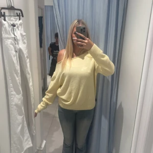 Ljusgul offshoulder stickad tröja - Superfin ljusgul stickad tröja med offshoulder-design och långa ärmar. Tröjan har en loose passform och bred ribbad mudd vid ärmslut och nederkant. Perfekt för dig som vill ha en chill och trendig look. Storleken är onesize, jag har vanligtvis xs/s. Nypris är runt 679kr.